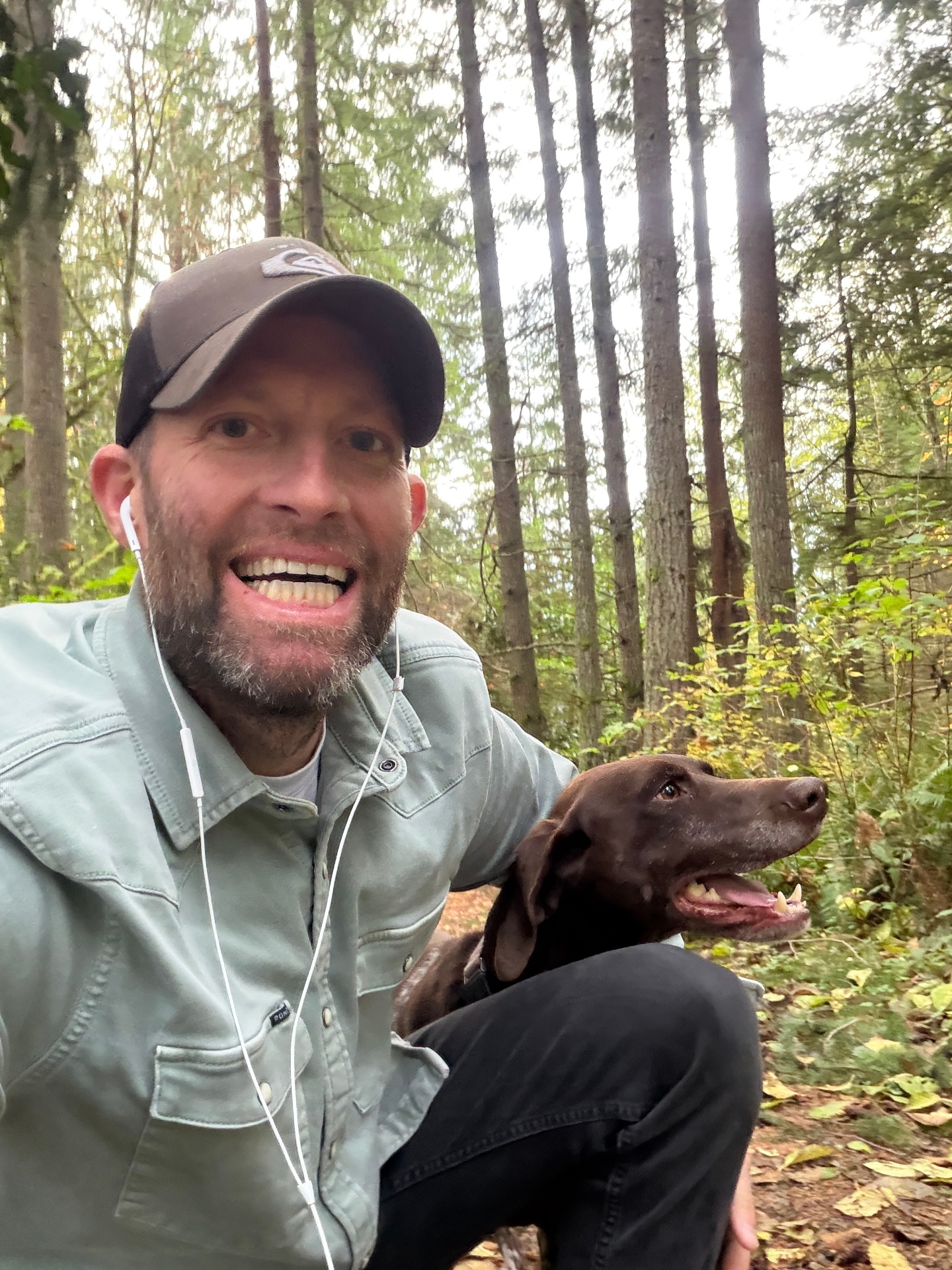 Ron Rougeaux hiking in an old-growth PNW forest with his chocolate lab